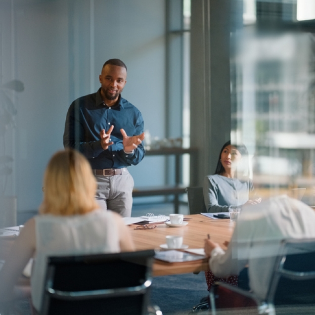 Businessman, meeting and discussion with office, boardroom and collaboration or workshop. Leader, training and presentation for mentor, coaching and strategy for teamwork and planning with startup