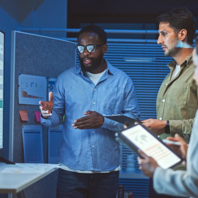 A team of multiethnic developers is meeting to review the data analysis of marketing from social media platforms.